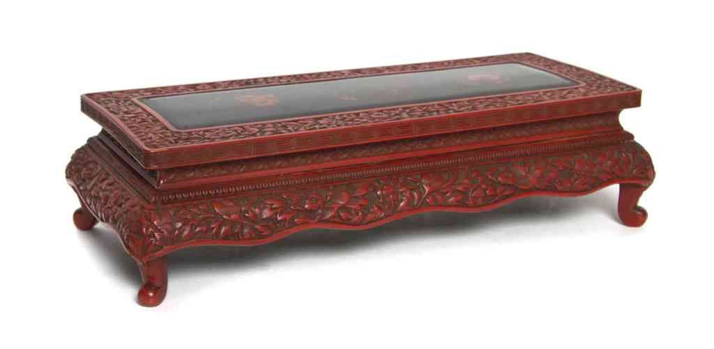 A Chinese Cinnabar Miniature Altar Table, Height 1: A Chinese Cinnabar Miniature Altar Table, having carved foliate decoration, the center panel painted with floral medallions, raised on four scrolling supports. Height 13 3/4 inches.