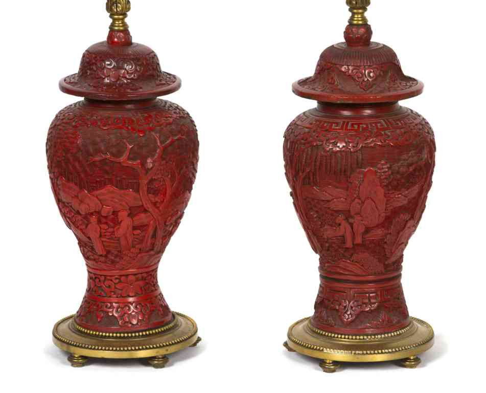 A Pair of Chinese Carved Cinnabar Lacquer Covered : A Pair of Chinese Carved Cinnabar Lacquer Covered Baluster Vases, relief carved depicting figures in a landscape with pine trees and mountains in the distance, raised on bronze bases, mounted as lamps