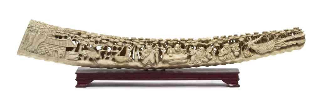 A Chinese Carved Ivory Tusk, Length 20 1/4 inches.: A Chinese Carved Ivory Tusk, having pierce carved decoration of a dragon and figures amongst trees. Length 20 1/4 inches.