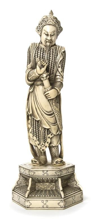 A Carved Ivory Figure of a Warrior, Height overall: A Carved Ivory Figure of a Warrior, depicting the armored figure drawing his sword, raised atop a hexagonal veneered ivory base. Height overall 15 3/4 inches.