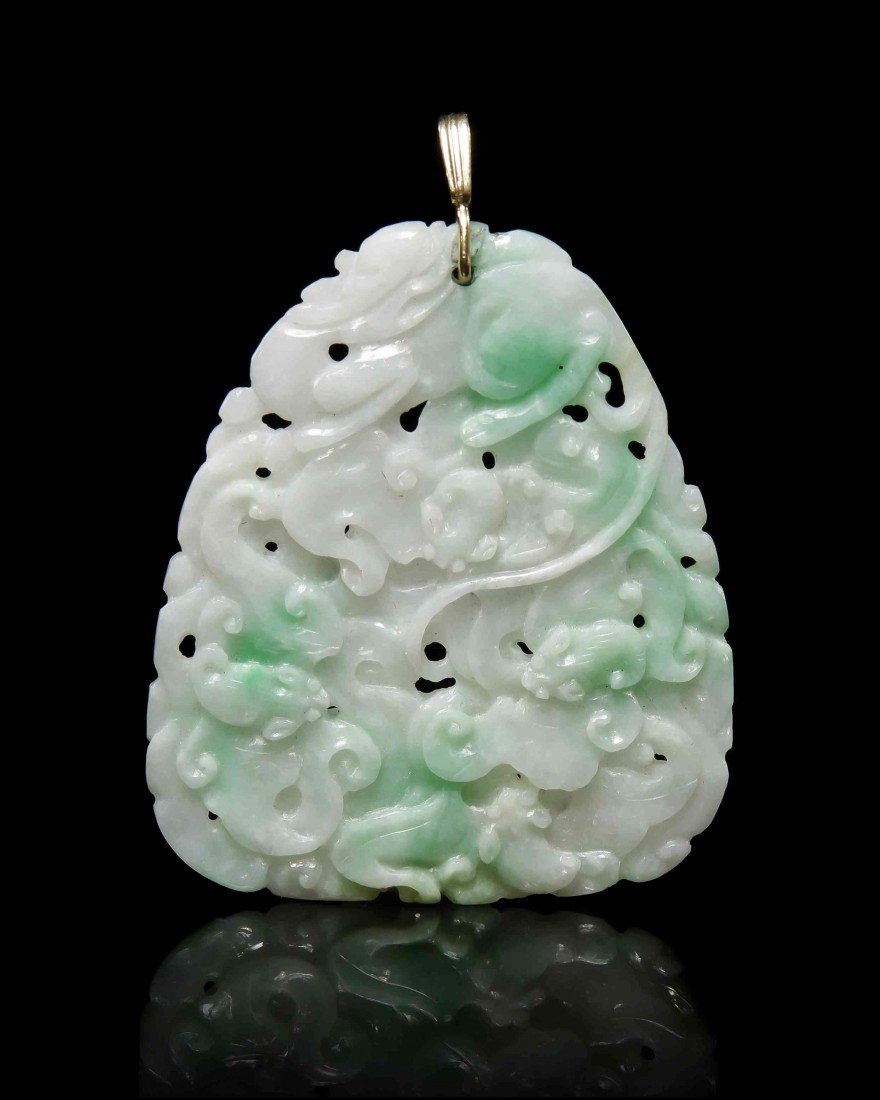 A Jadeite Pendent, Height 2 1/4 inches.: A Jadeite Pendent, of white and apple-green colored stone, the pear shaped pendant having relief carving throughout with bats and a beast at the top. Height 2 1/4 inches.