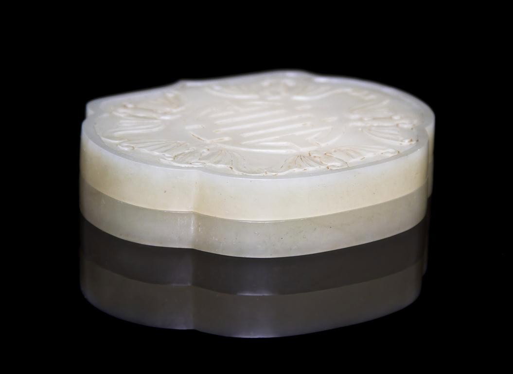 A Jade Box, Width 3 3/4 inches.: A Jade Box, in the form of the head of a ruyi scepter, the lid with relief carving of five bats with a central character, the underside having four character reign mark. Width 3 3/4 inches.