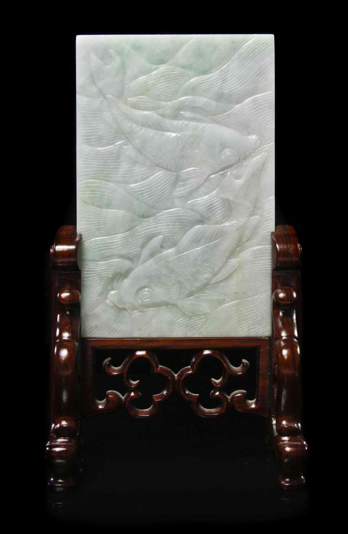 A Jadeite Table Screen, Height of 5 inches.: A Jadeite Table Screen, having carved decoration of two swimming fish, raised on a carved wood stand. Height of 5 inches.