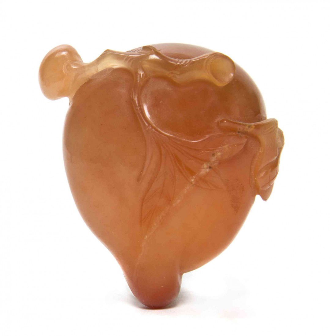 A Carnelian Peach-Form Snuff Bottle, Height 2 inch: A Carnelian Peach-Form Snuff Bottle, having carving of flowering branches and a bat at the side. Height 2 inches. Property from the Estate of Dr. Joseph and Donna Lee Boggs, Chicago, Illinois