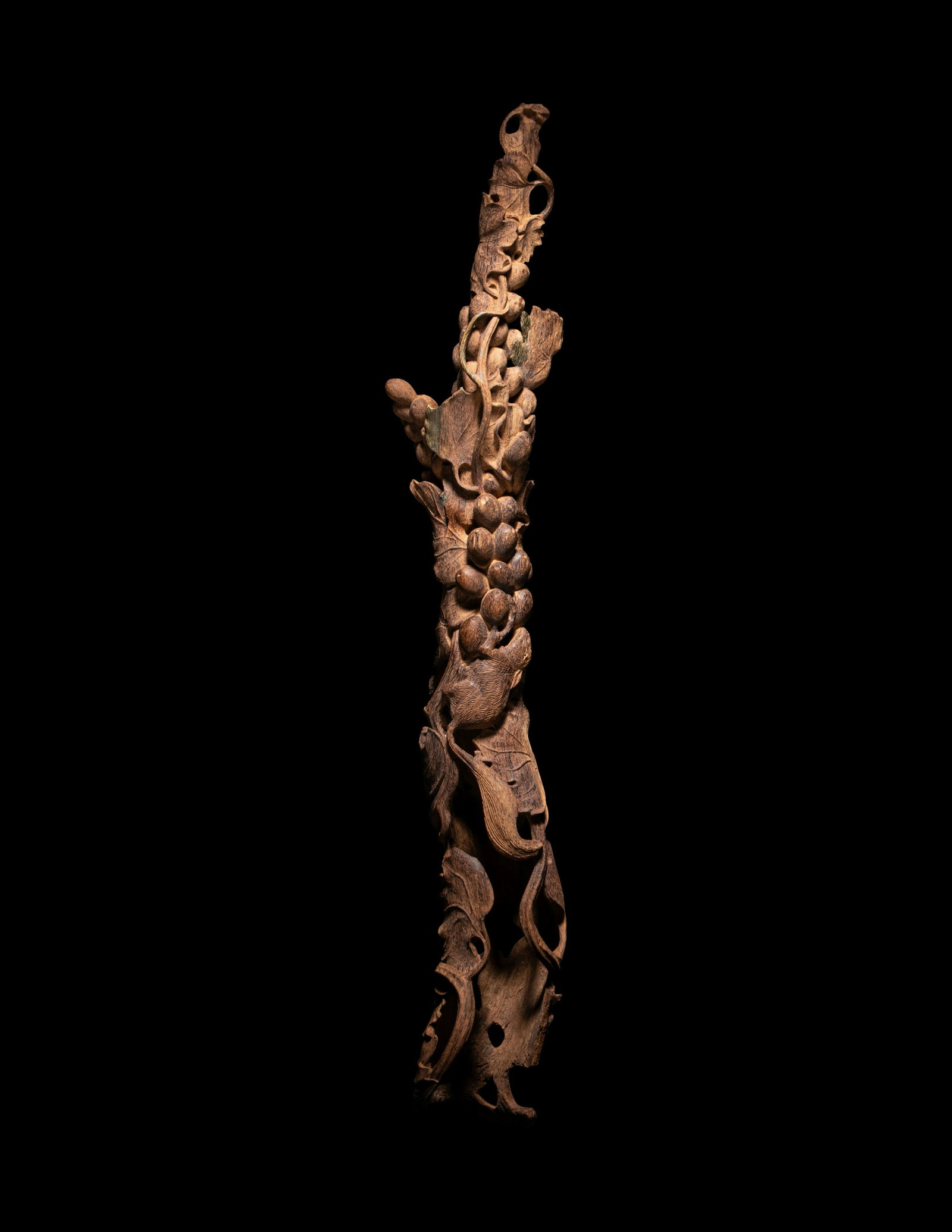 A Chinese Chenxiang Wood 'Squirrel and Grapes' Carving: A Chinese Chenxiang Wood 'Squirrel and Grapes' Carving 20th Century naturalistically carved to show a squirrel climbing on fruiting grape vines. Length 21 1/4 in., 54 cm. Property from a Private