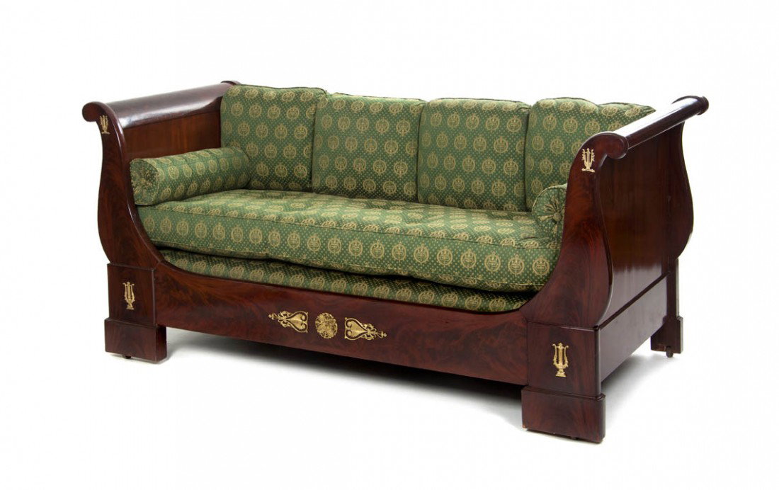 An Empire Mahogany and Gilt Bronze Mounted Day Bed: An Empire Mahogany and Gilt Bronze Mounted Day Bed, of typical form, with scrolling arms over the rectangular base, having classical mounts throughout. Width 84 1/2 inches.