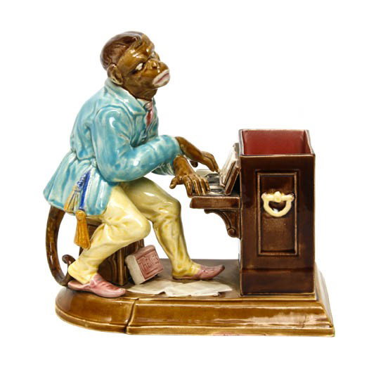 A Sarreguemines Majolica Figural Tobacco Jar, Heig: A Sarreguemines Majolica Figural Tobacco Jar, depicting a monkey seated at a piano. Height 9 1/8 inches.