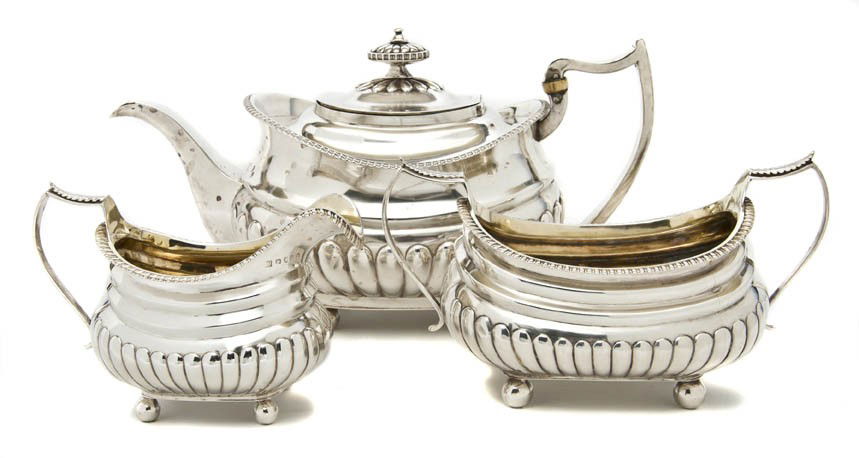 An English Silver Assembled Three-Piece Tea Set, W: An English Silver Assembled Three-Piece Tea Set, London, comprising a teapot, Solomon Hougham, 1812, the creamer and sugar, Thomas Johnson, 1812, each with lobed body, raised on spherical feet; approx
