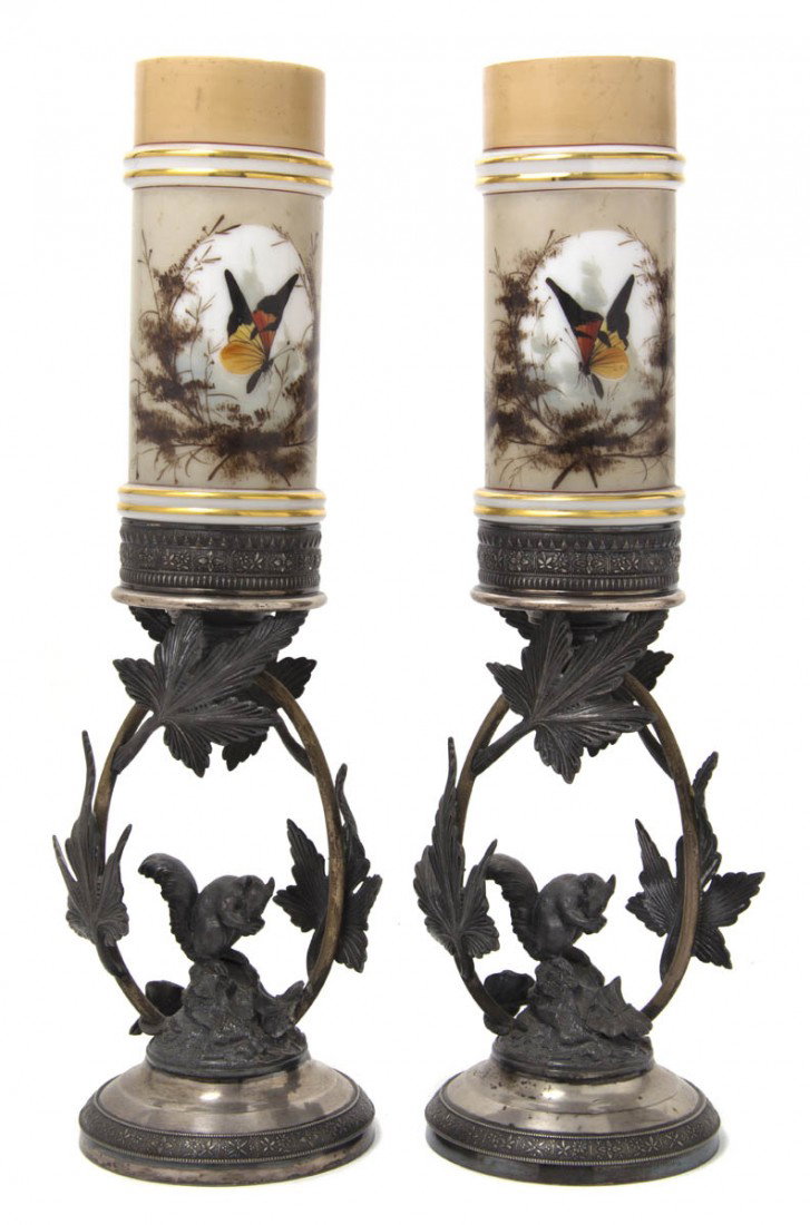 Two Victorian Silverplate and Glass Votive Holders: Two Victorian Silverplate and Glass Votive Holders, each with cylindrical diffuser with butterfly decoration, over the leafy base centered with a squirrel eating a nut. Height overall 17 inches.