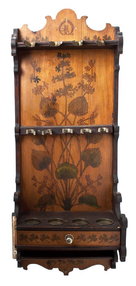 A Pyrographic and Ebonized Wood Pipe Rack, Height : A Pyrographic and Ebonized Wood Pipe Rack, of rectangular form, with a single drawer, having foliate and clover decoration. Height 32 inches.