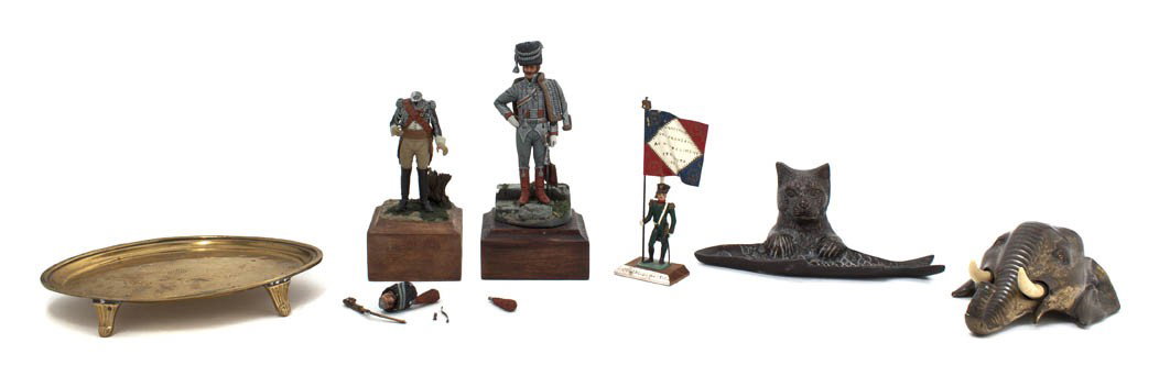 A Collection of Decorative Table Articles, Width o: A Collection of Decorative Table Articles, comprising a brass card tray, an elephant form table bell, a bear and fish pen tray and three cast metal figures of 19th century military figures. Width of f