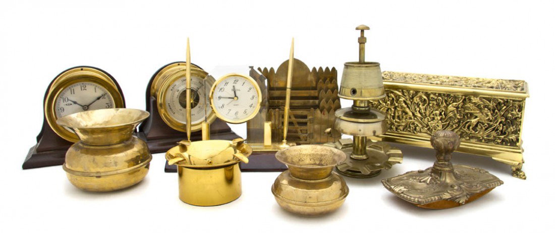A Collection of Brass Decorative Desk Articles, W: A Collection of Brass Decorative Desk Articles, comprising a clock and a barometer set, Chelsea, a repousse decorated table casket, two spittoons, a letter rack, a rocker blotter and others; 9 items t