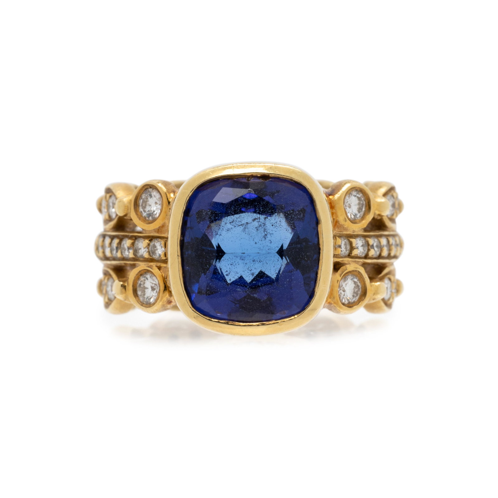YELLOW GOLD, TANZANITE AND DIAMOND RING: YELLOW GOLD, TANZANITE AND DIAMOND RING Containing one cushion mixed cut tanzanite measuring approximately 10.05 x 9.60 x 6.00 mm and 36 round brilliant cut diamonds weighing approximately 0.85 carat 