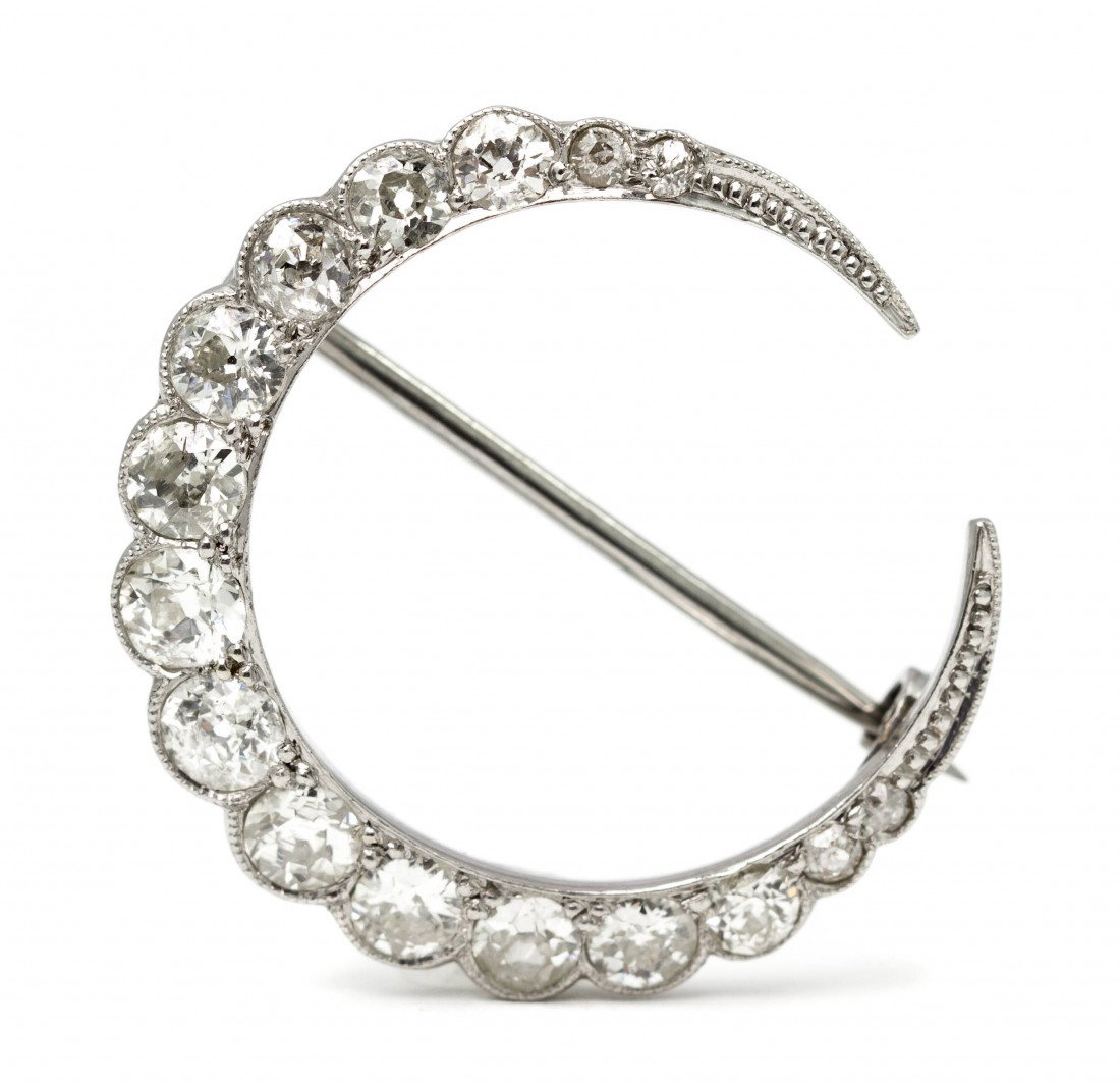 An Edwardian Platinum and Diamond Crescent Brooch,: An Edwardian Platinum and Diamond Crescent Brooch, containing 16 old European cut diamonds weighing approximately 1.50 carats total within a crescent shape setting with millegrain accents, white gold 