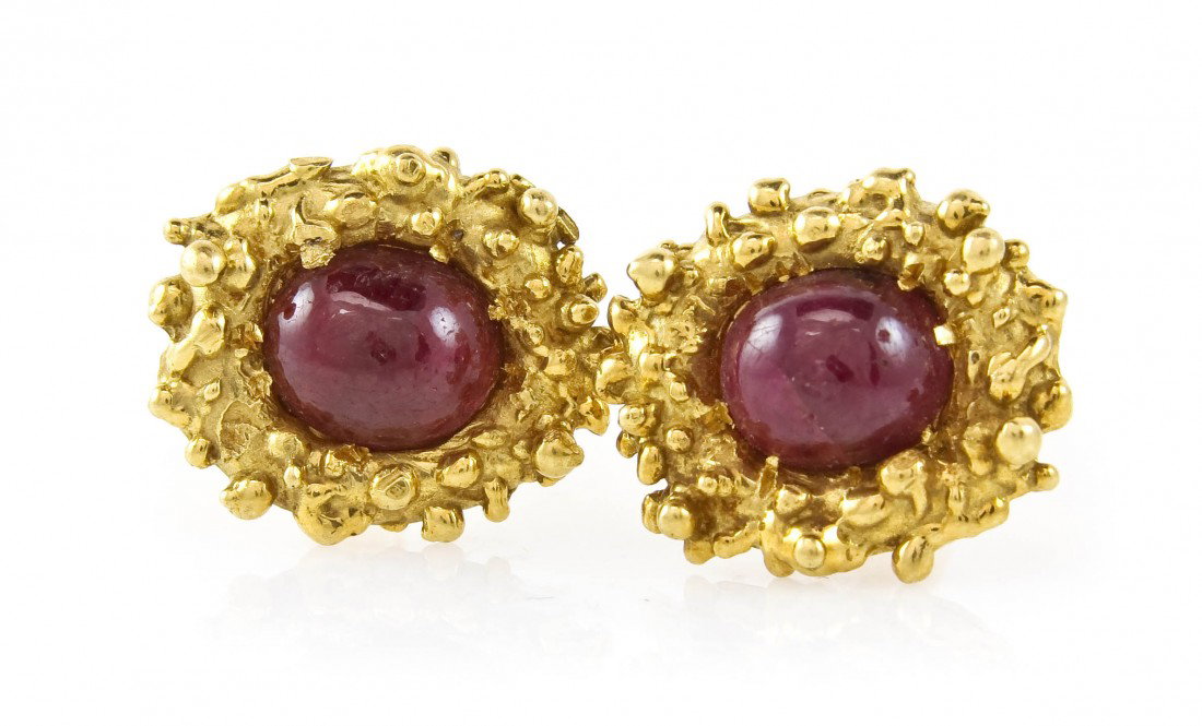 A Pair of 18 Karat Yellow Gold and Ruby Cufflinks,: A Pair of 18 Karat Yellow Gold and Ruby Cufflinks, containing two oval cabochon cut rubies within nugget finish settings. Stamp: 18K. 11.75 dwts. Property from the Estate of Barbara Miller Anton, Sara