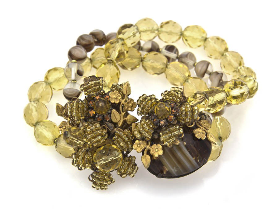 A Miriam Haskell Three Stand Bracelet,: A Miriam Haskell Three Stand Bracelet, with a floral beaded clasp. Stamped: Miriam Haskell.