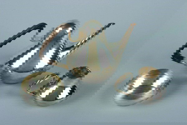 A Danish Three Piece Silver Coffee Service, Georg: A Danish Three Piece Silver Coffee Service, Georg Jensen Silversmithy, designed by Henning Koppel 1952, comprising a coffee pot, creamer, and sugar, numbered 1017; approximate weight of creamer and su