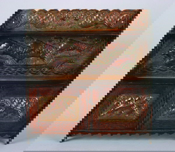 An English Arts and Crafts Oak Hanging Cupboard,: An English Arts and Crafts Oak Hanging Cupboard, John Pearson, 1894, having a copper embossed crest with foliate decoration over a medial shelf with a copper embossed back depicting a ship at sea over