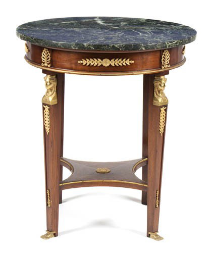 An Empire Mahogany and Gilt Bronze Mounted Guerido: An Empire Mahogany and Gilt Bronze Mounted Gueridon, having a circular marble top over the rosette and acanthus decorated frieze, raised on four square tapering legs with female masks and realisticall
