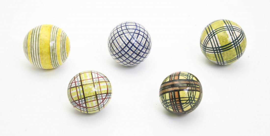 A Group of Five English Ceramic Carpet Balls, Diam: A Group of Five English Ceramic Carpet Balls, each with linear polychrome decoration. Diameter of largest 3 inches.