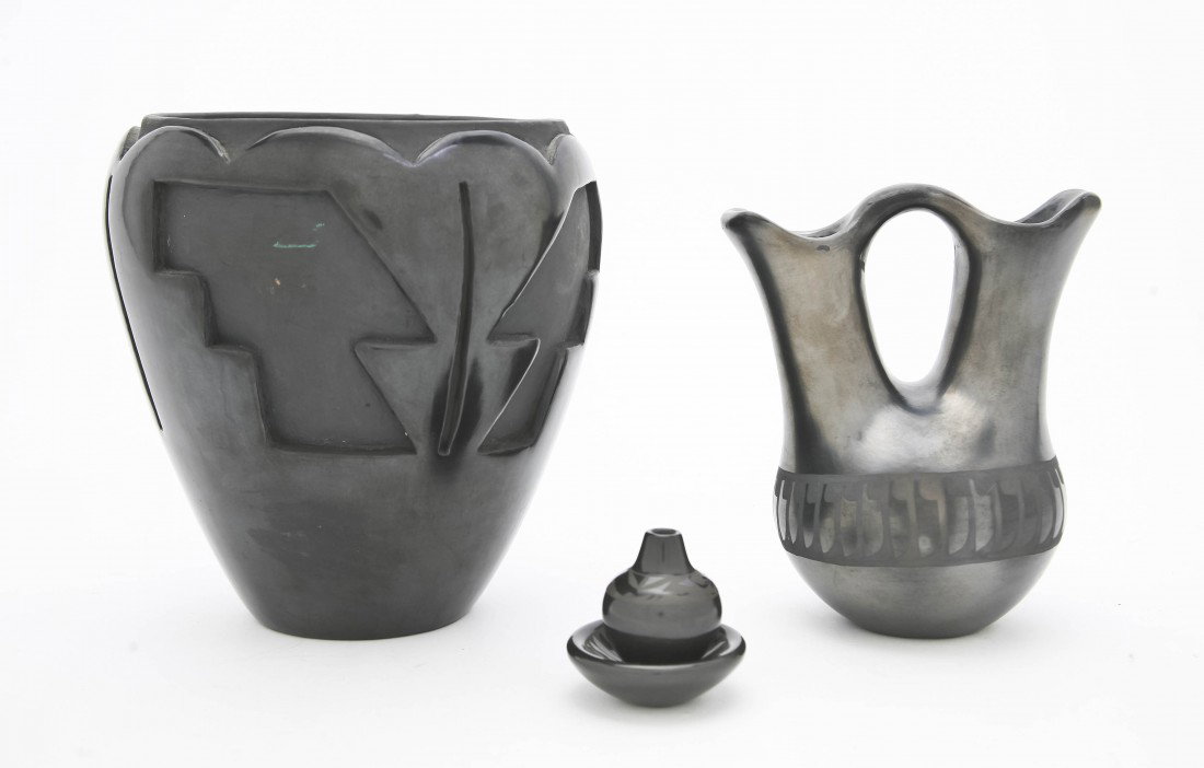 A Santa Clara Blackware Wedding Vessel, Santana an: A Santa Clara Blackware Wedding Vessel, Santana and Adam Martinez, having a band of repeating stylized feather decoration, together with a vase by Mida Tafoya having carved geometric decoration and tw