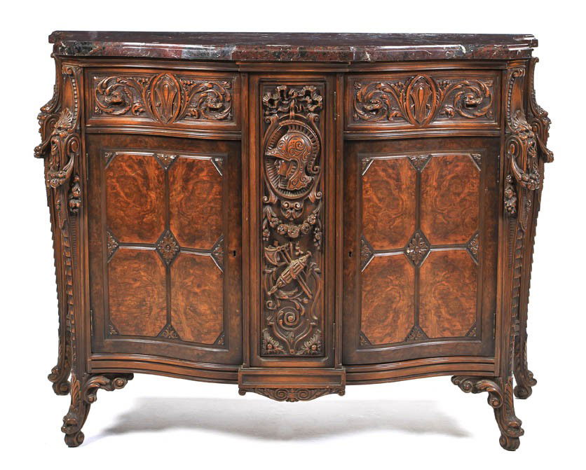 A Continental Neoclassical Console Cabinet, Height: A Continental Neoclassical Console Cabinet, having a shaped marble top over the conforming case above two drawers, over doors with carved figural and floral decoration throughout. Height 38 x width 48