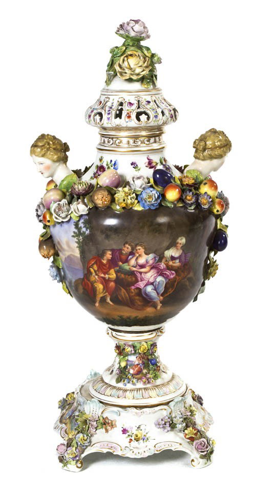 A German Porcelain Urn, Carl Thieme, Height overal: A German Porcelain Urn, Carl Thieme, in three parts with cap, body and pedestal, the body of baluster form with applied female mask handles and fruit and foliate swags, further decorated with figures 
