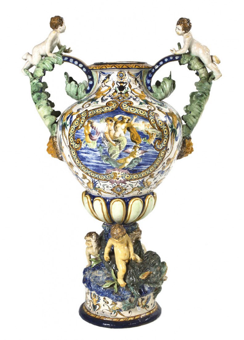 An Italian Faience Ceramic Urn, Height 28 inches.: An Italian Faience Ceramic Urn, of baluster handled form with applied putti figures and lion masks, further decorated with figures in a landscape. Height 28 inches.
