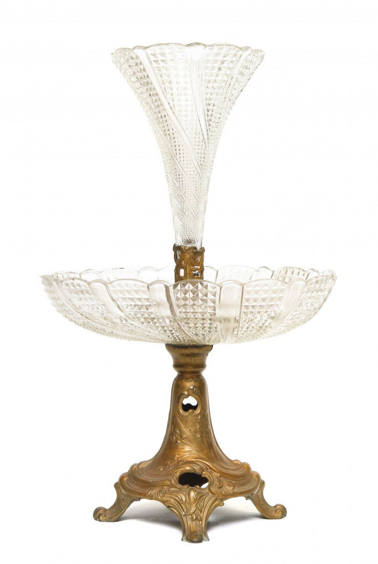 A Continental Pressed Glass Two-Tier Epergne, Hei: A Continental Pressed Glass Two-Tier Epergne, having a trumpet form upper tier with pressed swirl pattern over an oval bowl raised on a bellflower decorated gilt metal base. Height 15 inches.