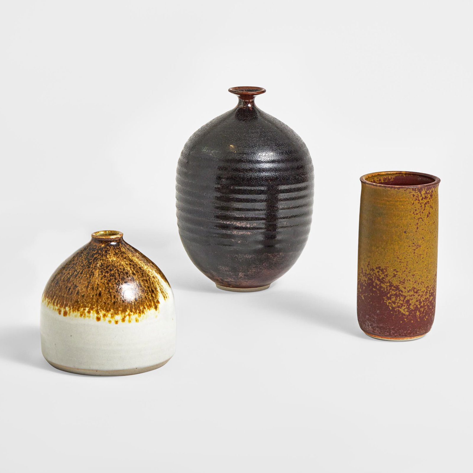 Brother Thomas Bezanson (Canadian-American, 1929-2007) Three Porcelain Vases, USA, circa last: Brother Thomas Bezanson (Canadian-American, 1929-2007) Three Porcelain Vases, USA, circa last quarter 20th century Porcelain, iron and textured iron glaze, textured Tenmoku glazeIncised to underside o