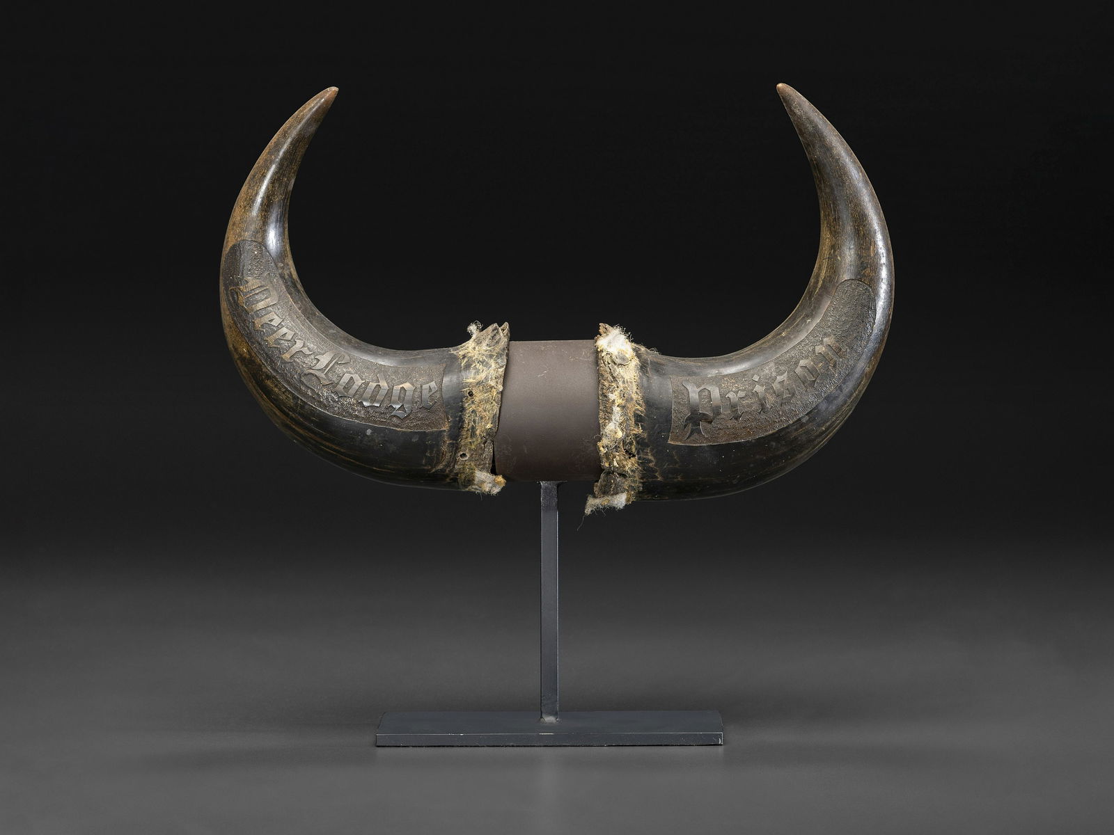A Pair of Montana Prisoner Folk Art Carved Bison Horns: A Pair of Montana Prisoner Folk Art Carved Bison Horns Late 19th Century engraved on one side Deer Lodge Prison and Harry Woolrich on the other. Height 14 inches. Harry Woolrich was a notorious gamble