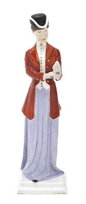 A Meissen Porcelain Figure, Height 13 7/8 inches.: A Meissen Porcelain Figure, depicting a standing lady wearing a red riding coat, holding a crop and adjusting her gloves, raised on a square stepped base, having crossed swords mark in underglaze blue