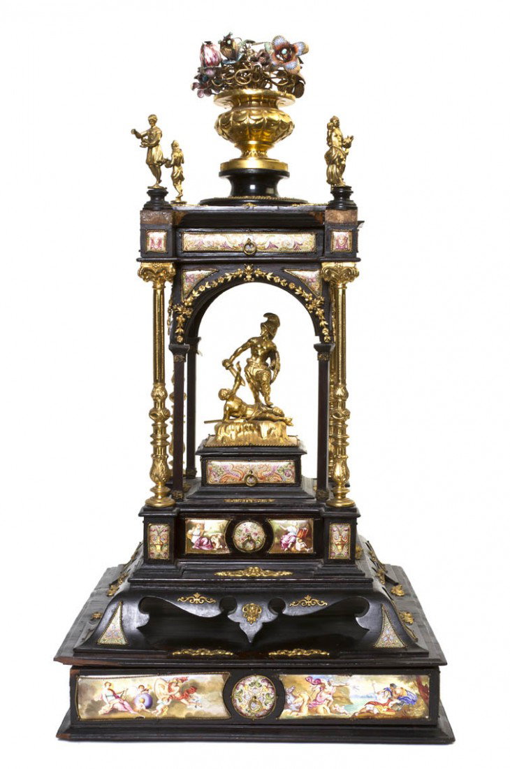 A Continental Ebonized, Enameled and Parcel Gilt C: A Continental Ebonized, Enameled and Parcel Gilt Centerpiece, of portico form, surmounted by a flowering urn centering four figural finials over a figural group depicting a Roman soldier slaying a man