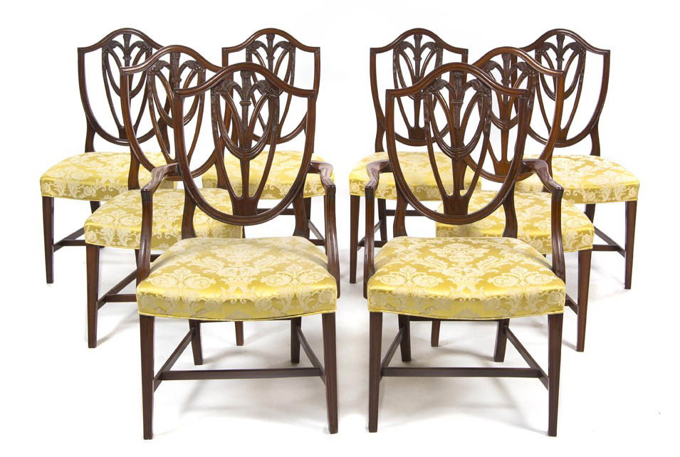A Set of Eight American Hepplewhite Style Dining C: A Set of Eight American Hepplewhite Style Dining Chairs, comprising six side chairs and two armchairs, each having a pierced shield form back with a fleur-de-lis and garland splat over the upholstered
