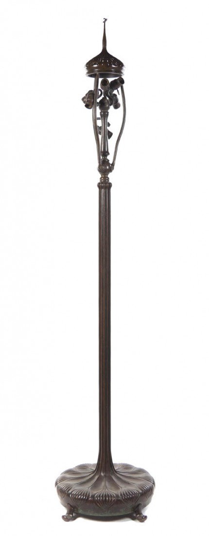 A Tiffany Studios Bronze Senior Floor Lamp Base, H: A Tiffany Studios Bronze Senior Floor Lamp Base, having heat cap with rattail finial over the six-light cluster, the circular base with stylized foliate decoration, raised atop three feet, marked Tiff