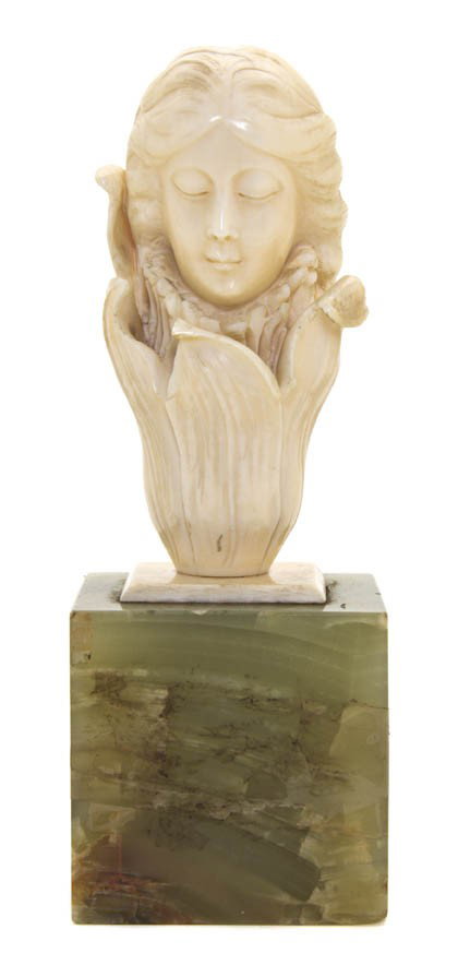 A Continental Art Nouveau Ivory Bust, Height 5 1/4: A Continental Art Nouveau Ivory Bust, depicting a lady issuing from a lily, set on an onyx plinth base. Height 5 1/4 inches.