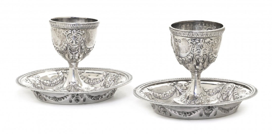 A Pair of English Silver Egg Cups with Underplates: A Pair of English Silver Egg Cups with Underplates, London Assay Office, 1946, having classical repousse mask and foliate swag decoration throughout, with gadrooned edges and applied serpent, butterfl