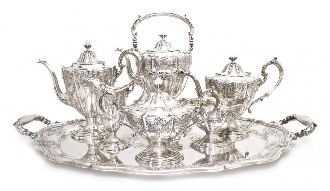 An American Sterling Silver Tea and Coffee Servic: An American Sterling Silver Tea and Coffee Service, Gorham, each of faceted tapering form with shell and foliate decoration comprising a coffee pot, tea pot, and hot water kettle on stand with ivory i
