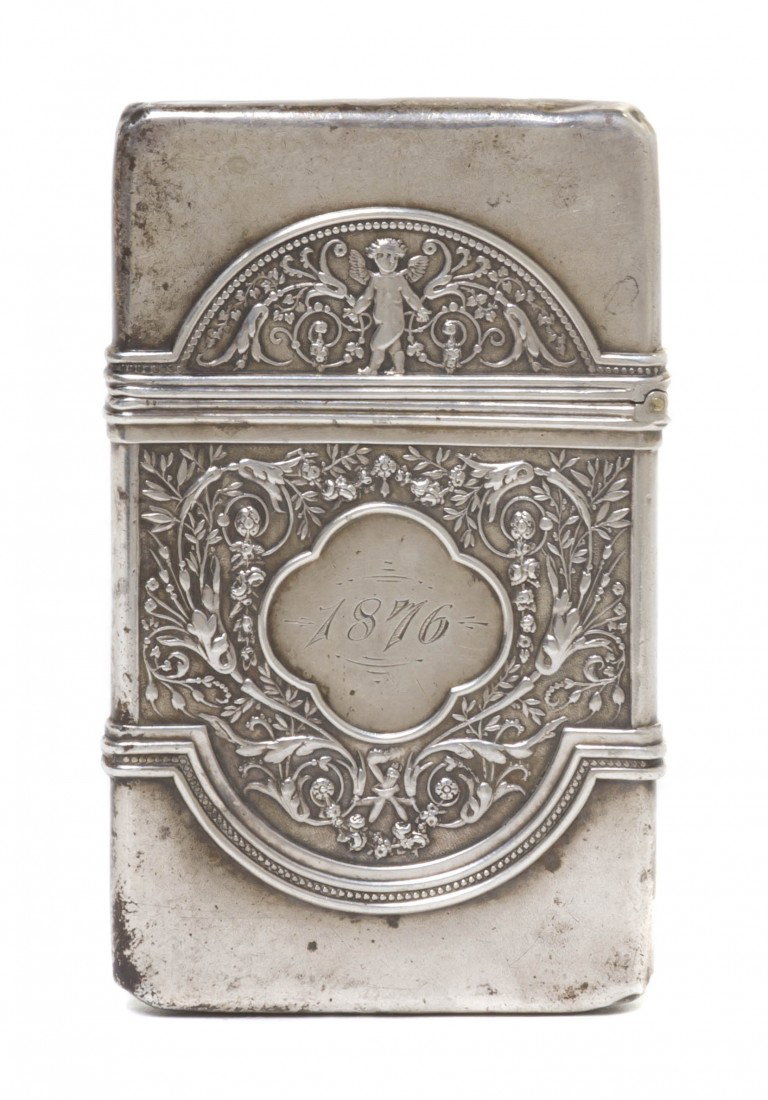 An American Sterling Silver Cigarette Case, Gorha: An American Sterling Silver Cigarette Case, Gorham, of rectangular form having repousse decoration with a putto amidst scrolling foliate fields, centered with a cartouche reading Jenny from Edward, th