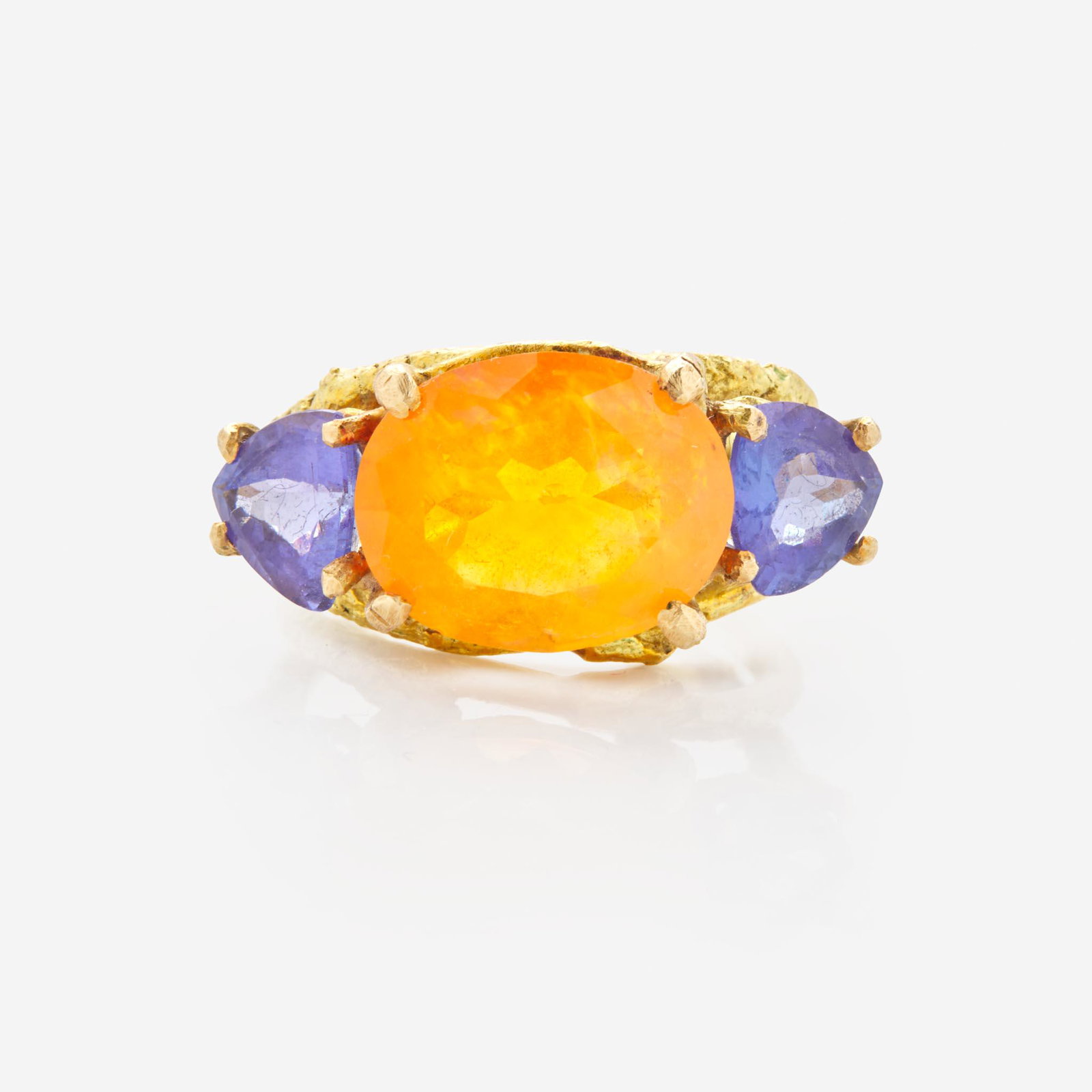 A 14K Fire Opal and Tanzanite Ring by Sam Shaw: A 14K Fire Opal and Tanzanite Ring by Sam Shaw A 14K yellow gold ring by Sam Shaw of Maine, centering an oval-cut fire opal measuring approximately 14.17mm x 11.26mm, flanked by two trillion-cut tanza