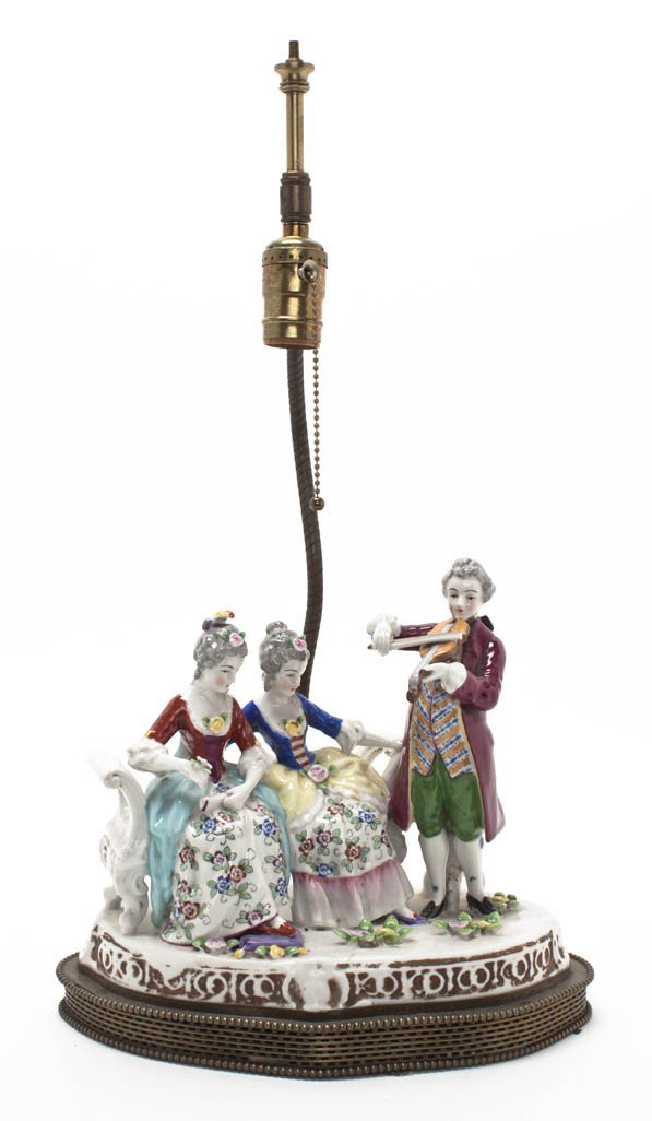 A Continental Porcelain Figural Group, Height ove: A Continental Porcelain Figural Group, depicting a gentleman playing a violin before two seated ladies, mounted as a lamp. Height overall 21 inches.
