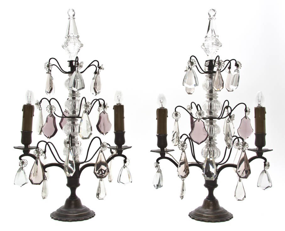 A Pair of Continental Cast Metal and Glass Two-Li: A Pair of Continental Cast Metal and Glass Two-Light Girandoles, each of baluster form hung with prisms throughout. Height 19 1/4 inches. Property from the Estate of Jean Ross, Lake Forest, Illinois