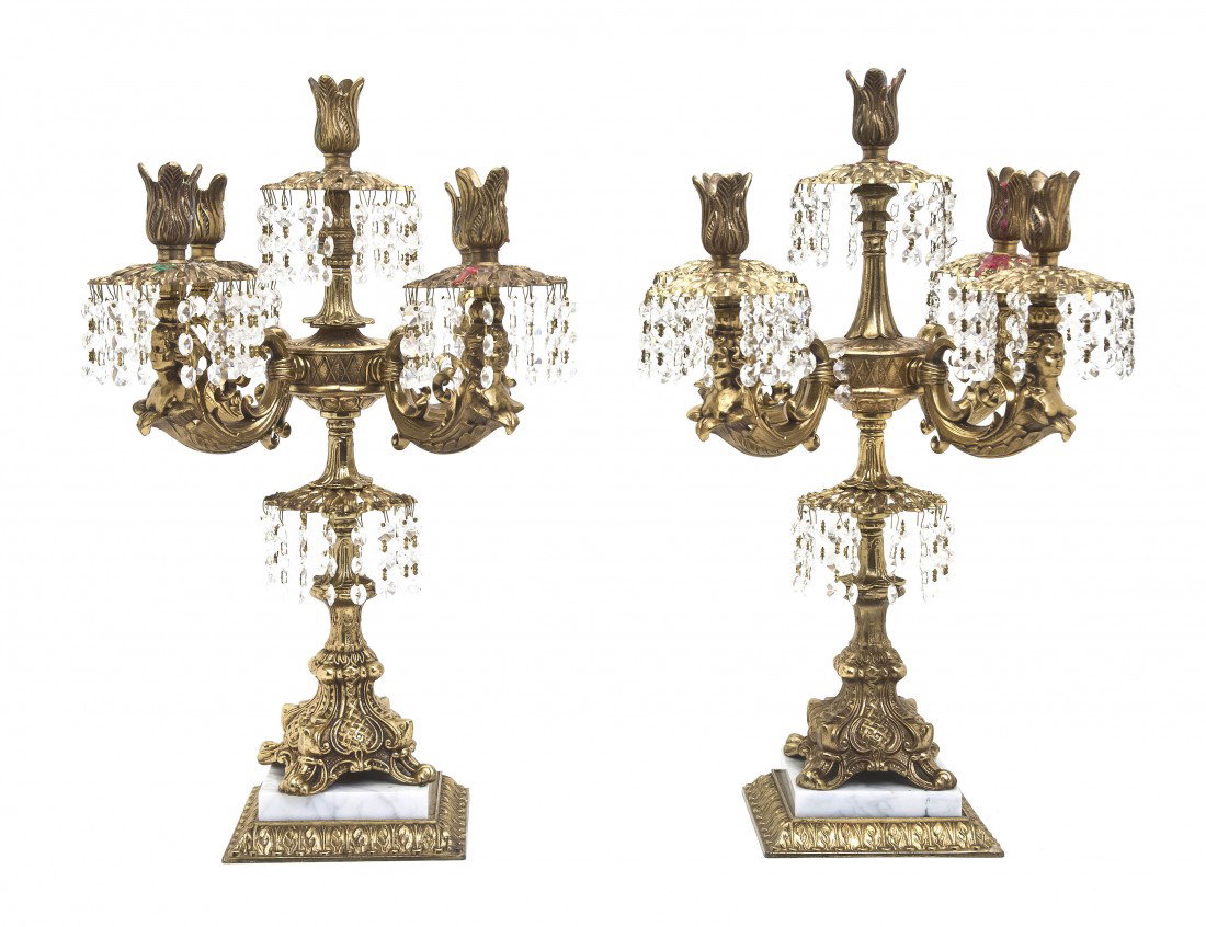 A Pair of Gilt Metal Five-Light Candelabra, Heigh: A Pair of Gilt Metal Five-Light Candelabra, the baluster form standard issuing the scrolling candle arms, hung with prisms throughout. Height 21 inches. Property from the Leon Brown Trust, U.S. Bank, 