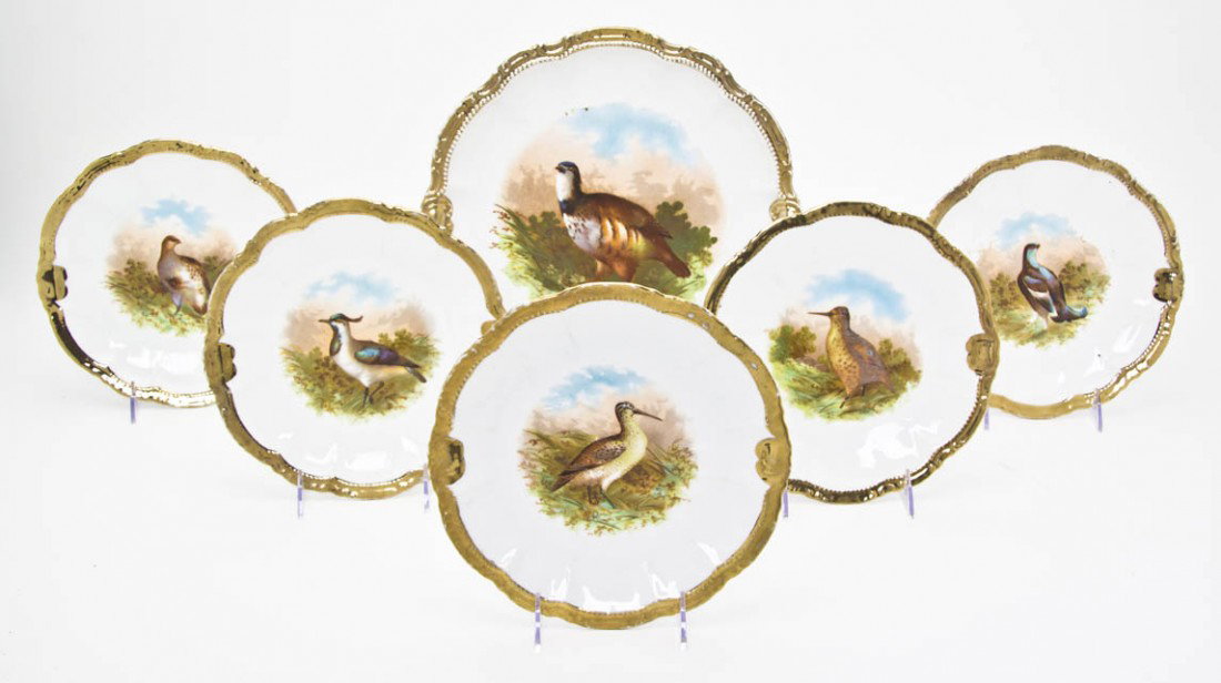A Bavarian Porcelain Dessert Service, Diameter of: A Bavarian Porcelain Dessert Service, comprising a cake platter and six plates painted with various game birds within gilt borders. Diameter of largest 12 5/8 inches.