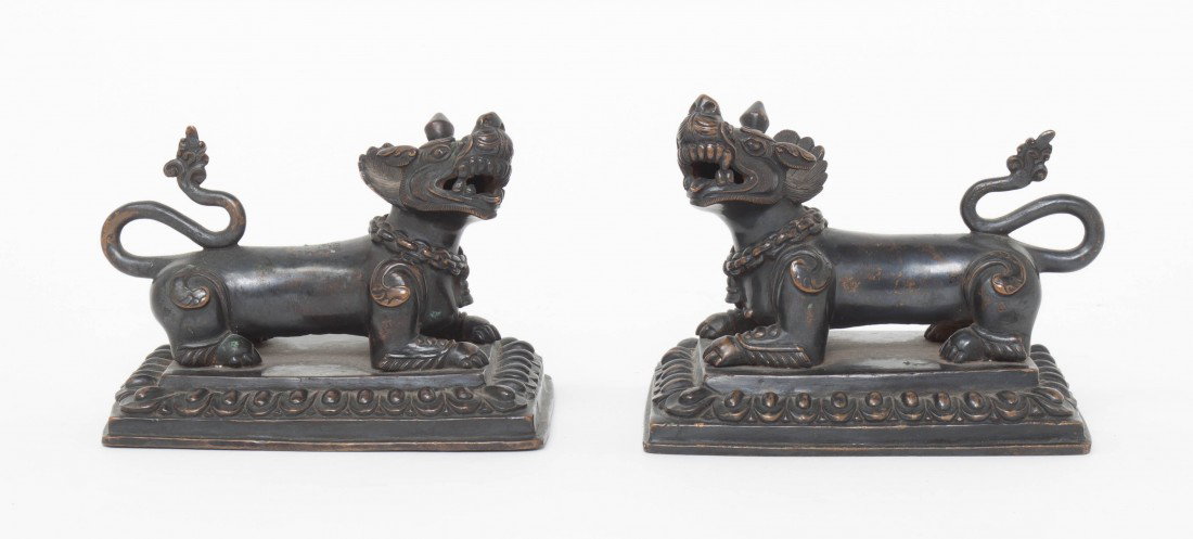 A Pair of Southeast Asian Bronze Lions, Height 3 : A Pair of Southeast Asian Bronze Lions, depicted in opposing, crouched stances, raised on rectangular bases with lotus petal borders. Height 3 1/2 inches.