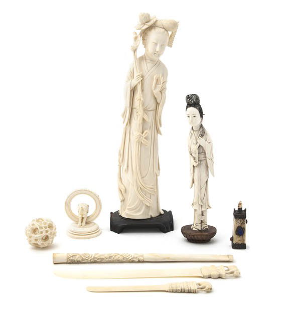 A Group of Eight Chinese Ivory Articles, Height o: A Group of Eight Chinese Ivory Articles, comprising a puzzleball, two letter openers, two figures of women, a figure of an elephant, a cigarette extender and a bottle. Height of tallest 10 1/4 inches.