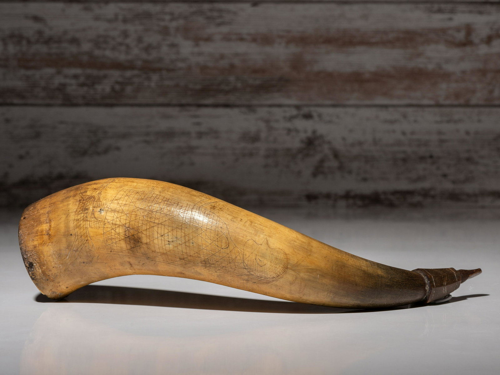 Great Lakes Incised Powder Horn: Great Lakes Incised Powder Horn 19th century incised with a tall figure holding a rifle and standing on a smaller, galloping horse; a bow and arrow pointed directly at his mid-section length 13 inches