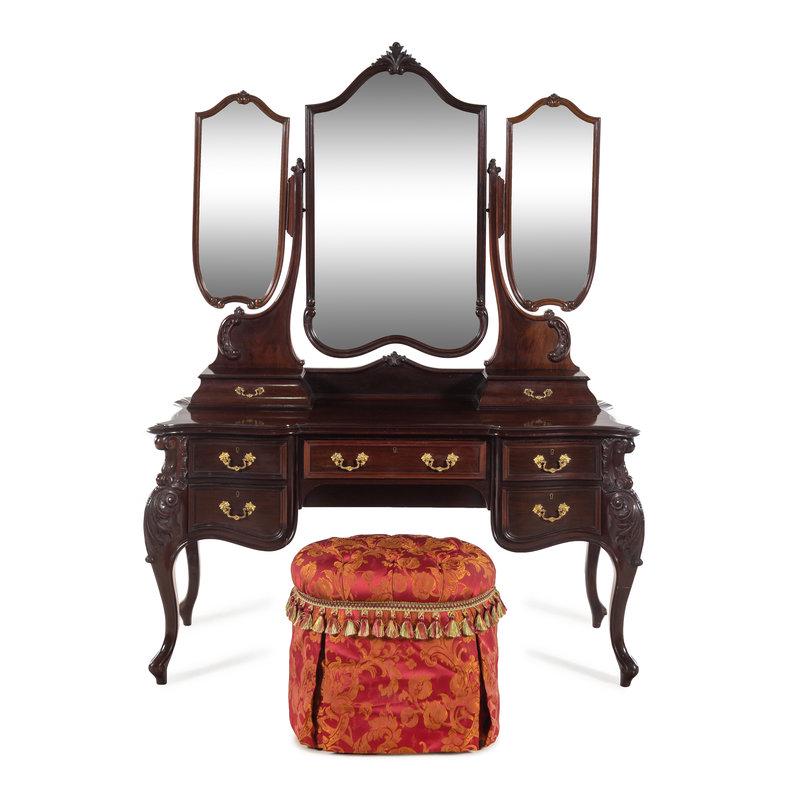 An English Mahogany Dressing Table with a Three-Part Mirror: An English Mahogany Dressing Table with a Three-Part Mirror Waring and Gillow, London, Early 20th Century together with an associated upholstered stool. Height 76 x width 58 x depth 25 inches.<