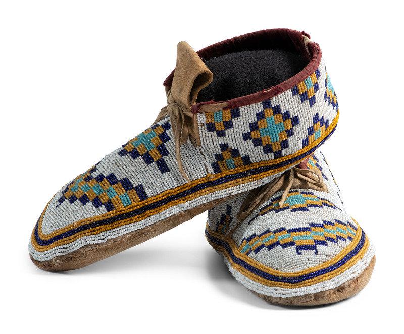 Plains Cree Beaded Hide Moccasins: Plains Cree Beaded Hide Moccasins ca 1900 thread-sewn, with canvas uppers and hide soles; uppers beaded in colors of gold, deep blue, light blue, and white; velveteen interior length 10 in