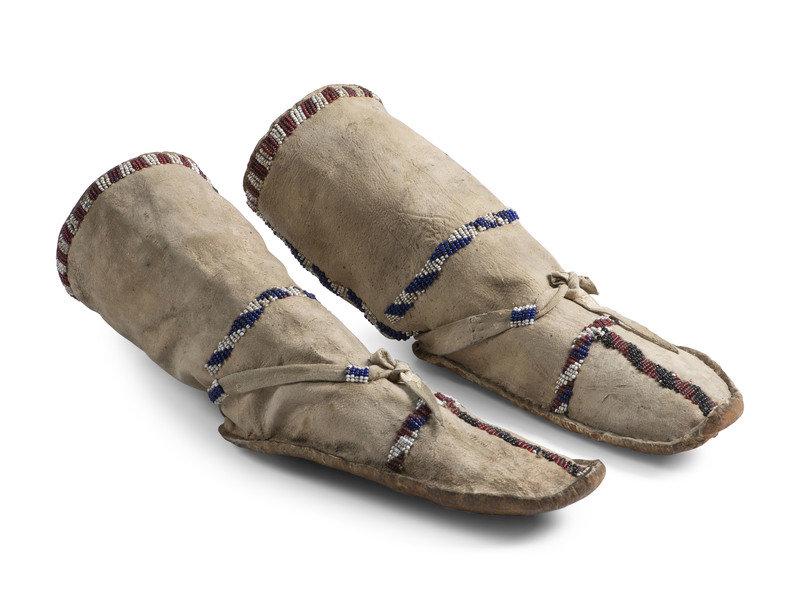 Apache Beaded Hide Boot Moccasins: Apache Beaded Hide Boot Moccasins ca 1900 sinew-sewn and beaded with colors of dark blue, rose, white, and cobalt height 13 inches x length 9-1/2 inches This lot is locate